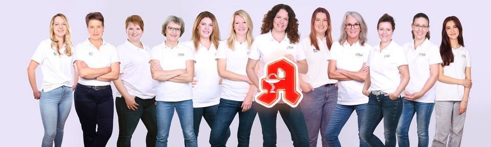 Eine Gruppe von 12 Apothekenmitarbeiterinnen die in einer Reihe stehen.